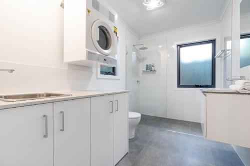 堪培拉Cosy 1 BR unit in Ainslie的白色的浴室设有卫生间和水槽。