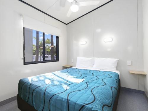 特万庭Ingenia Holidays Noosa North的一间卧室配有一张带蓝色棉被的床