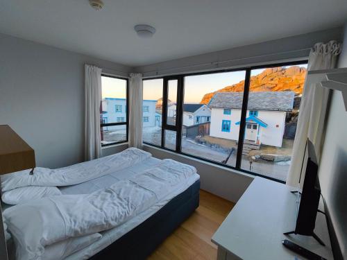Hamn塞尼亚岛港口酒店的一间卧室配有一张床、一张书桌和一个窗户。