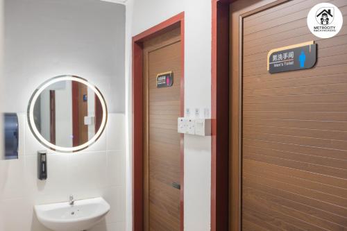 古晋MetroCity Backpackers的浴室设有门、水槽和镜子