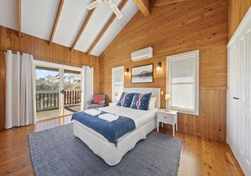 波高尔宾North Lodge Highland Cottage的一间卧室设有一张大床和木墙