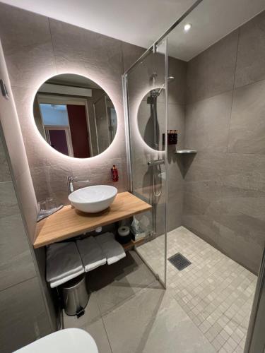 Sandöverken高海岸酒店的浴室配有盥洗盆和带镜子的淋浴