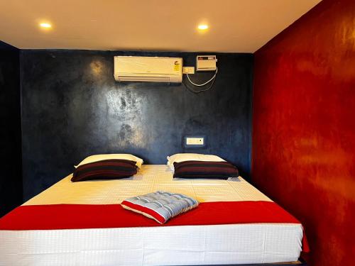 蓬蒂切里Nature Zone Resort的卧室配有红色和白色的床和风扇