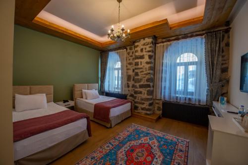 卡尔斯Ve Hotels Beylerbeyi Sarayı的一间卧室设有两张床和一个水槽,窗户