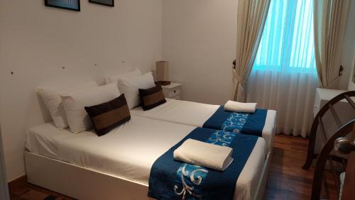 亭可马里Beach Paradise Nilaveli的一间卧室配有一张白色的床和蓝色的毯子