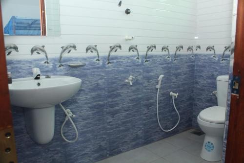 蒂瑟默哈拉默Thirasara Holiday Resort的墙上设有鸟淋浴的浴室