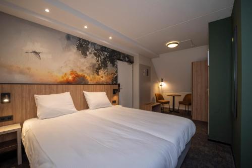 阿尔森弗莱彻罗兰德餐厅酒店的卧室配有白色的床和墙上的绘画作品