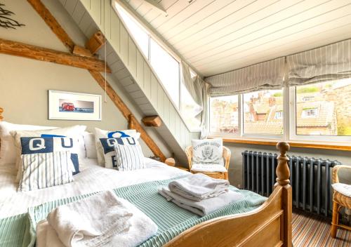 罗宾胡兹贝Green Cottage的一间卧室配有一张带蓝色和白色枕头的床