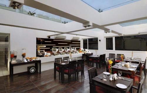 新德里Hotel Grand Godwin - Near New Delhi Railway Station - Paharganj的餐厅内带桌椅的用餐室