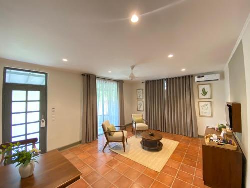 尼甘布Tamarind Tree Garden Resort - Katunayake的客厅配有两把椅子和一张桌子