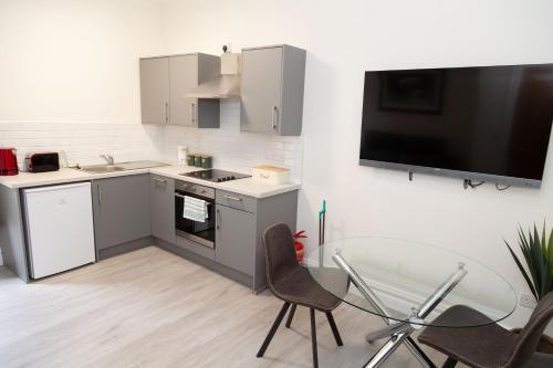 科芙Unit 1 Island View Apartments - Town Centre Walk To Everything的厨房配有电视和桌椅。