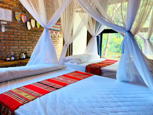 Hương Bá ThướcPu Luong Riverside Lodge的一间卧室配有两张床和窗帘