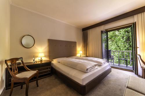 梅拉诺伊莎贝拉酒店的一间卧室设有一张床、一个窗口和一把椅子