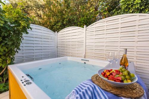 斯基亚索斯镇Skiathos Avaton Garden, Philian Hotels and Resorts的浴缸里放着一碗水果和一瓶葡萄酒