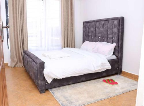 NyahururuLulu Stays 2 Bedroom的卧室内一张带黑色皮革床头板的床