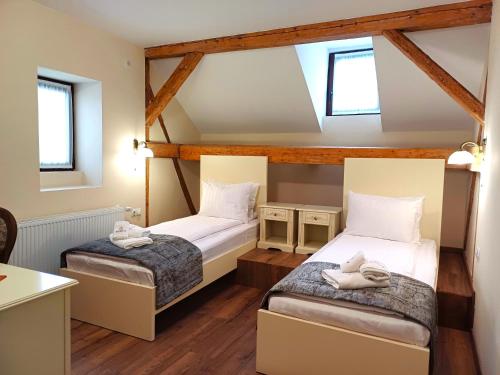 锡盖图马尔马切伊Casa Huber的客房内设有两张床,铺有木地板,设有窗户。