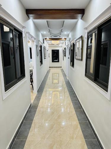 伊斯兰堡Moven Inn Hotel Islamabad的一条带白色墙壁的走廊和一条带窗户的长走廊