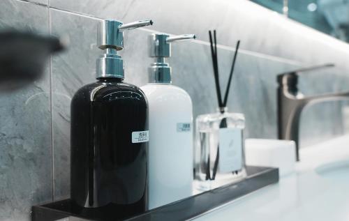 杭州一只柠萌酒店（杭州西湖解放路店）的浴室的柜台上放上两个肥皂瓶