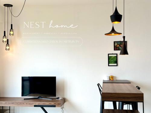 新山Cube 8teens by Nest Home的客厅配有书桌、电视和桌子