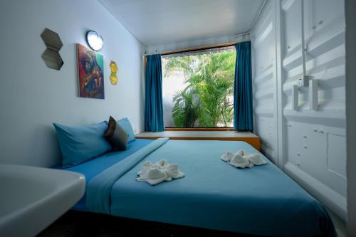 暹粒White Rabbit Hostel的一间卧室设有蓝色的床和窗户。