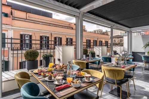 罗马CC Palace Hotel的阳台餐厅设有桌椅和食物