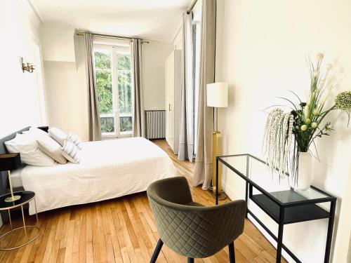 伊居利Grand appartement d'exception au Château Randin的一间卧室配有一张床、一张桌子和一把椅子