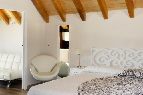 哈兰迪雅·德·拉·维尔Complejo Rural La Coronilla的白色卧室配有床和椅子
