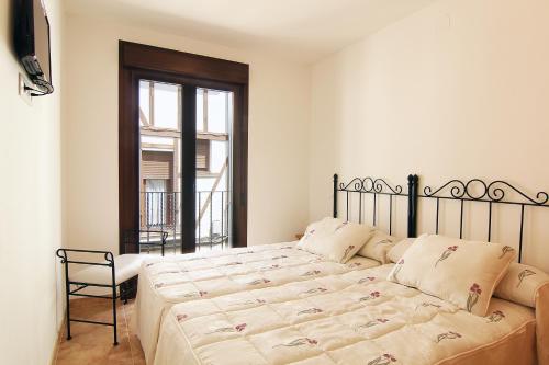坎德莱达耶希旅舍的卧室配有床、椅子和窗户。