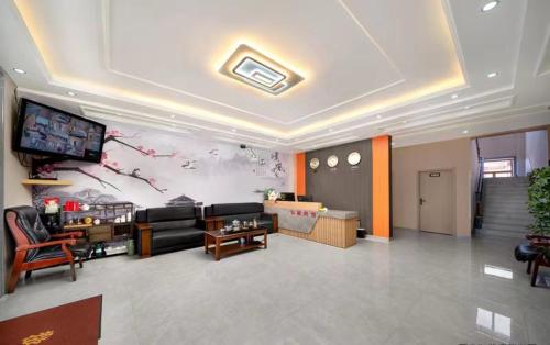 哈尔滨Hongge Hotel - Harbin Taiping Airport的带沙发和电视的客厅