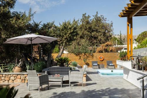拉多斯Villa Perla的庭院配有桌椅和遮阳伞。