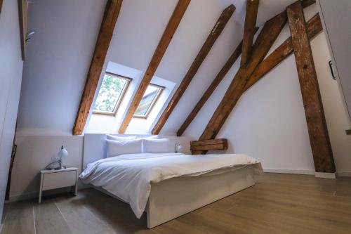 卢戈日Palatul Lugoj的卧室配有一张床铺,位于带木梁的房间