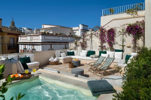 塞维利亚Casa del Rey Sabio的一座带游泳池和家具的屋顶露台
