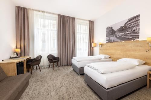 布达佩斯城市之环酒店的酒店客房,设有两张床和一张沙发