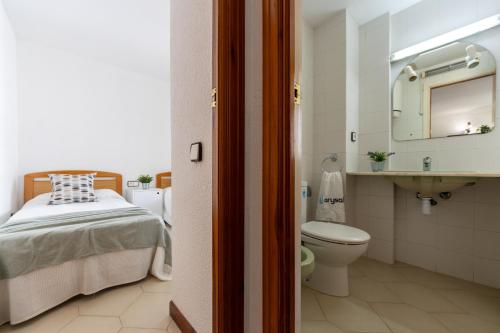 萨洛诺维特阿尔萨公寓的浴室设有床、卫生间和水槽。