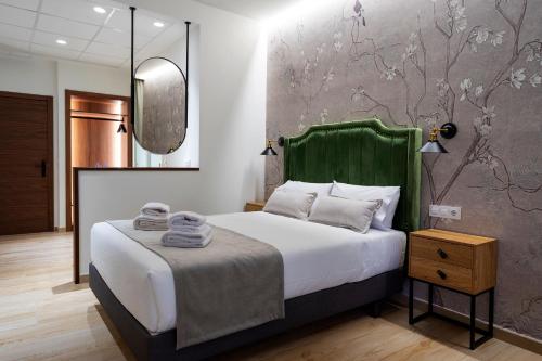Zarza la MayorComplejo Valle Grande的一间卧室配有一张带绿色床头板和镜子的床