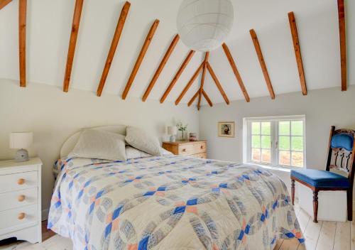 Little BarninghamAurora Cottage的一间卧室配有一张床和一张蓝色椅子