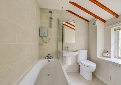 Little BarninghamAurora Cottage的带浴缸、卫生间和盥洗盆的浴室
