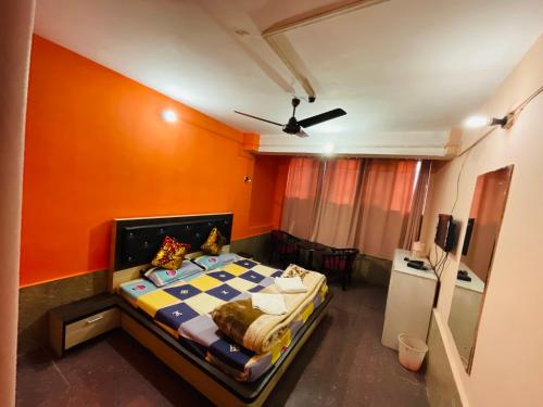 斯利那加hotel new sahil的一间卧室配有一张橙色墙壁的床
