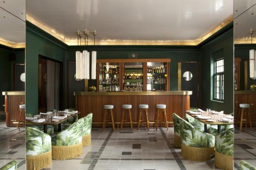 瓜达拉哈拉Casa Habita, a Member of Design Hotels的两间带绿色墙壁的餐厅和一间酒吧
