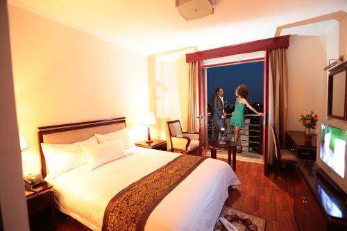 亚的斯亚贝巴Wassamar Hotel的一间设有床铺、男女的房间