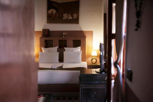 马拉喀什阿利利摩洛哥传统庭院的一间卧室配有带白色枕头的床