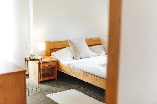 ChvalšinyPenzion Adien的一间卧室配有一张木床和一个带床头柜的卧室