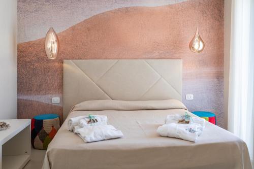 托雷苏达Le Gemelle Boutique Hotel的一间卧室配有带毛巾的床