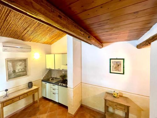 罗通多港Domo s'Altura的厨房拥有白色的墙壁和木制天花板。