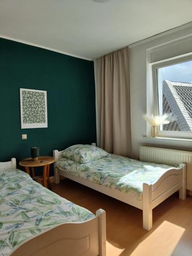 韦策Guesthouse in Weeze的一间卧室设有两张床和窗户。