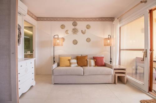 马里纳·迪·波迪斯科Portisco Bouganville Seaside Charm Flat W/ Veranda的客厅配有沙发和两盏灯。