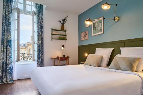 波尔多Hôtel Bordeaux Clémenceau by Happyculture的卧室设有一张白色大床和一扇窗户。