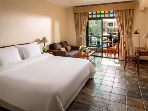 麦纳麦巴林铝达纳度假村诺富特酒店的一间带大床的卧室和一间客厅