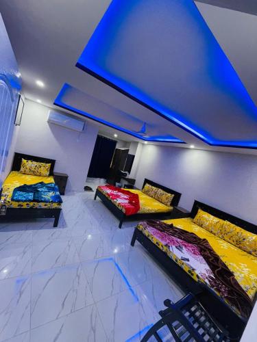 伊斯兰堡Moven Inn Hotel Islamabad的蓝色天花板的客房内的两张床