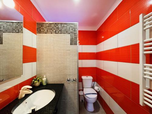 Casa Luz Apartamento 3的红色和白色的浴室设有水槽和卫生间